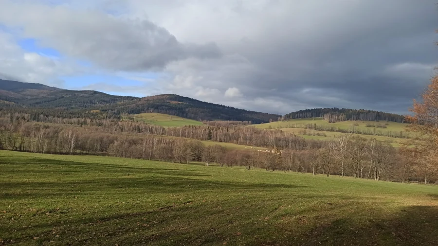 Louky a horské hřebeny pod mraky